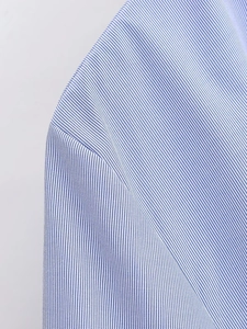 Close-up of blue and white striped shirt fabric showing fine texture and stitching