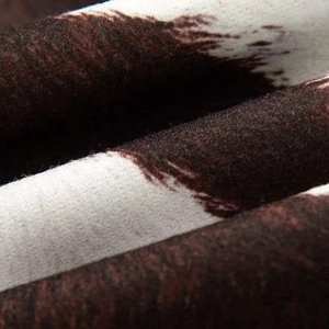 Macro shot of faux fur cow print fabric texture with soft plush fleece material detail