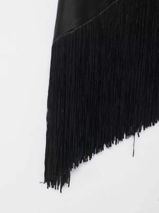 Detail of black silk top featuring long irregular fringe trim and asymmetric hemline