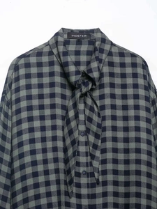 Detail of gingham shirt with tie-neck bow and button-down front in navy and green