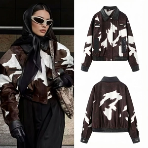 Detail of cow print jacket featuring contrast black faux leather collar and trim