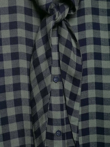 Detail of dark blue and grey-green plaid shirt with dark navy buttons and woven texture