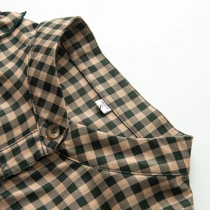 Detail view of green checked shirt with amber buttons and collar size label S