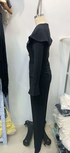 Dettaglio del completo nero a due pezzi in maglia con ampi revers e polsini svasati