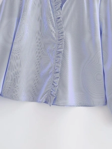 Detailed close-up of blue and white vertical striped shirt with elegant ruffle trim detail