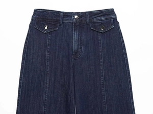 Dettaglio di jeans a vita alta blu scuro con bottoni argento e design tasca con patta