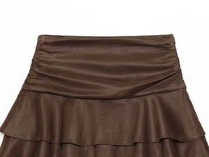 Détail d'une jupe plissée marron foncé à volants avec tissu texturé et taille large