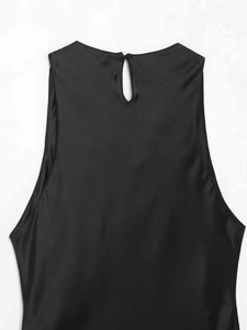 Detail of the back neckline with keyhole button closure on black satin sleeveless top