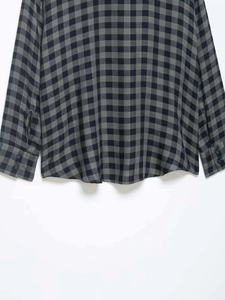 Detail of green plaid shirt showing button cuffs and high-quality cotton fabric texture