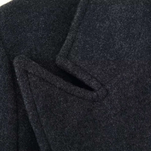 Minimalist charcoal grey wool overcoat featuring a premium three-button design and sleek lapel
