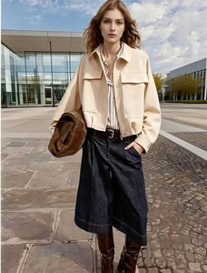 Dettaglio della giacca corta beige stile utility con grandi tasche a patta e bottoni