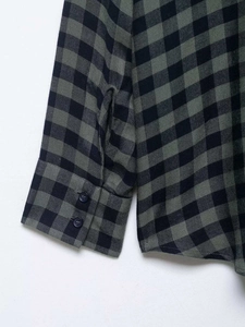 Detail of green plaid shirt showing double-button cuffs and high-quality fabric texture