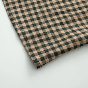 Detail shot of the fine black and brown gingham fabric and high-quality hem stitching