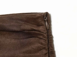 Vue détaillée de la fermeture éclair invisible et du tissu plissé sur la jupe marron