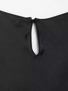 Close-up of black sleeveless top featuring a keyhole back cutout and button closure