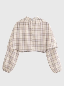 Detail view of the cropped plaid top featuring high neck and layered shawl design