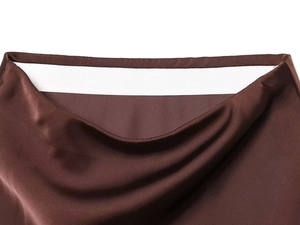 Dettaglio dell'elastico interno in vita di una gonna asimmetrica in raso marrone