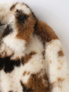 Dettaglio del collo in ecopelliccia con densa trama maculata marrone e crema e materiale morbido