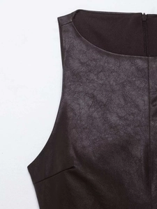 Détail de l'épaule et de la fermeture éclair invisible d'une robe en similicuir marron