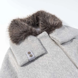 Détail d'une veste en laine avec col en fausse fourrure marron et fermeture éclair en métal
