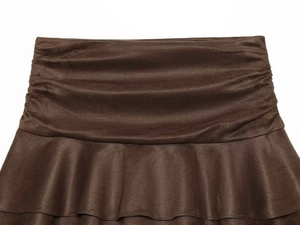 Vue détaillée d'une mini-jupe marron foncé avec plis superposés et volants élégants