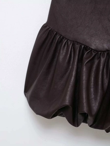 Détail de l'ourlet de la robe en cuir marron foncé avec volants plissés élégants