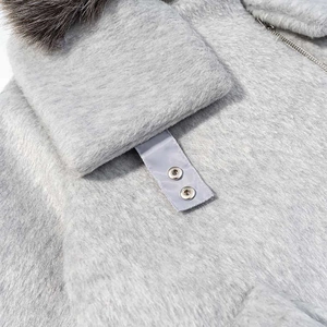 Détail de la veste grise en peluche avec fermeture éclair et col en fausse fourrure