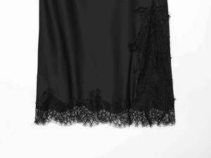 Detailed view of smooth black satin skirt featuring elegant eyelash lace trim and refined finish