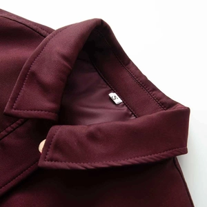 Dettaglio del colletto bomber bordeaux con trama del tessuto e etichetta taglia S