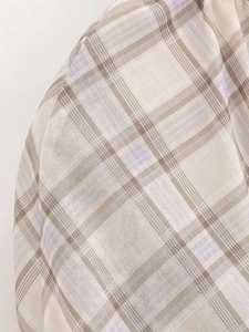 Detailed close-up showing beige and white plaid fabric texture with lavender lines