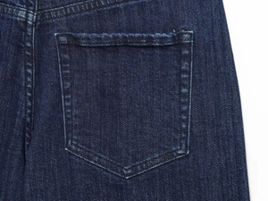 Dettaglio ravvicinato della tasca posteriore di jeans blu scuro con cuciture bianche