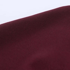 Close-up of wine red knitted fabric texture with a fine mesh pattern detail