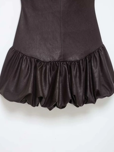Gros plan détaillé de l'ourlet bulle et de la couture sur une robe courte en cuir marron