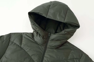 Close-up of olive green hooded down jacket with quilted pattern and black front zipper