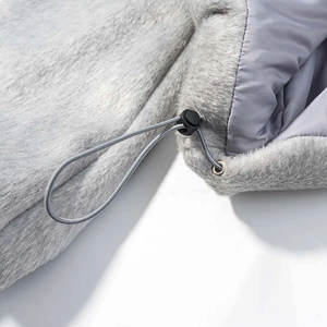 Détail d'une veste grise en fausse fourrure avec texture pelucheuse et cordon de serrage