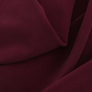 Detailed macro view of deep red pleated fabric texture and elegant draping quality