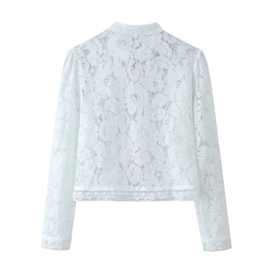 Detail of white lace top featuring mandarin collar and intricate floral pattern embroidery