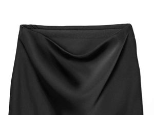 Detail of high-gloss black satin skirt with elastic waistband and smooth silk texture