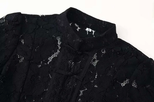 Detail view of the black lace texture and traditional Chinese button knot on the top