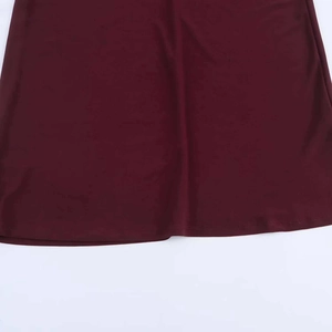 Detailed view of the double-stitched hem on a burgundy knit draped cowl neck dress