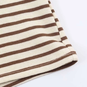 Macro shot of striped knit fabric showing fine ribbed texture and neat hem stitching
