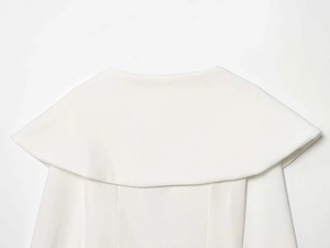 Dettaglio di un elegante top bianco con grande colletto a scialle rotondo e tessuto a trama