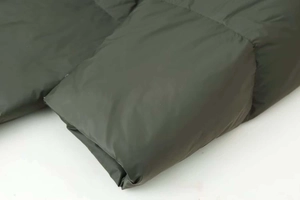 Detail shot of the olive green quilted puffer coat with high-quality windproof stitching
