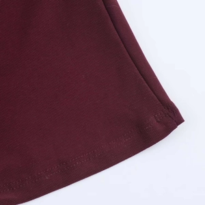Detailed close-up showing the double-stitched hem on burgundy twill fabric dress