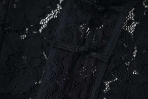 Detailed macro view of elegant black floral lace fabric with traditional Chinese knot buttons