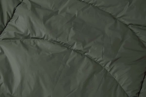 Close-up of deep olive green quilted down jacket fabric with high-density stitching