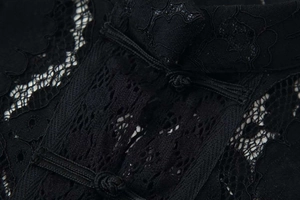 Detailed close-up of intricate black lace texture and traditional Chinese frog buttons