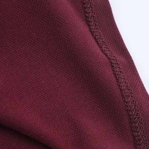 Macro shot showing fine seam stitching and wine red fabric texture of the summer dress