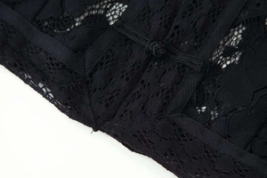 Close-up of black floral lace fabric with exquisite Chinese frog button fasteners