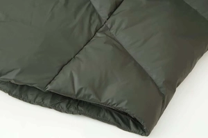 Detailed macro view of military green quilted down jacket showing high-quality stitching
